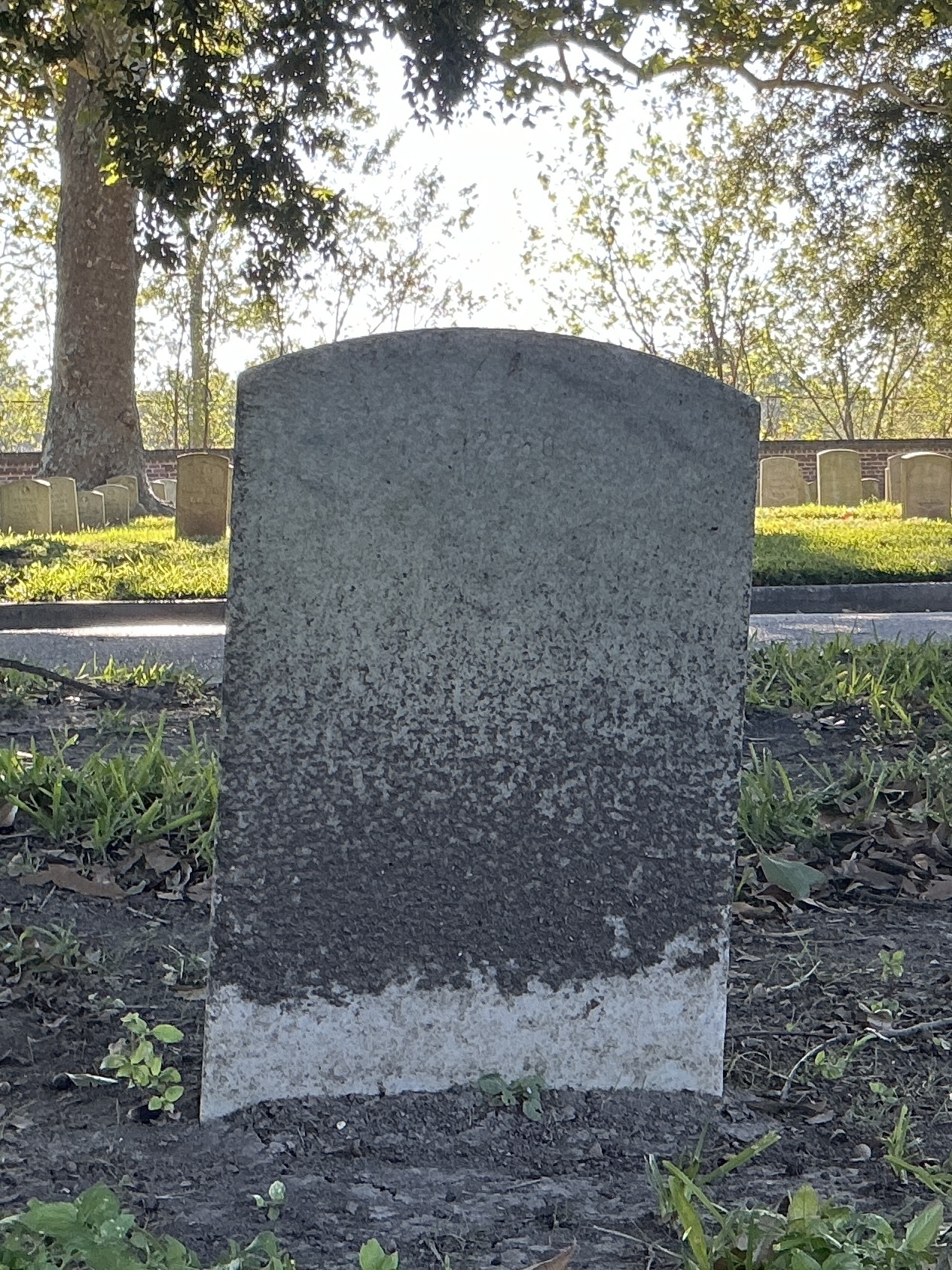 Back of upright marble headstone with flat face.