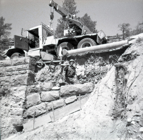 Crane placing rock bricks during the repair of retaining wall along East Rim road.