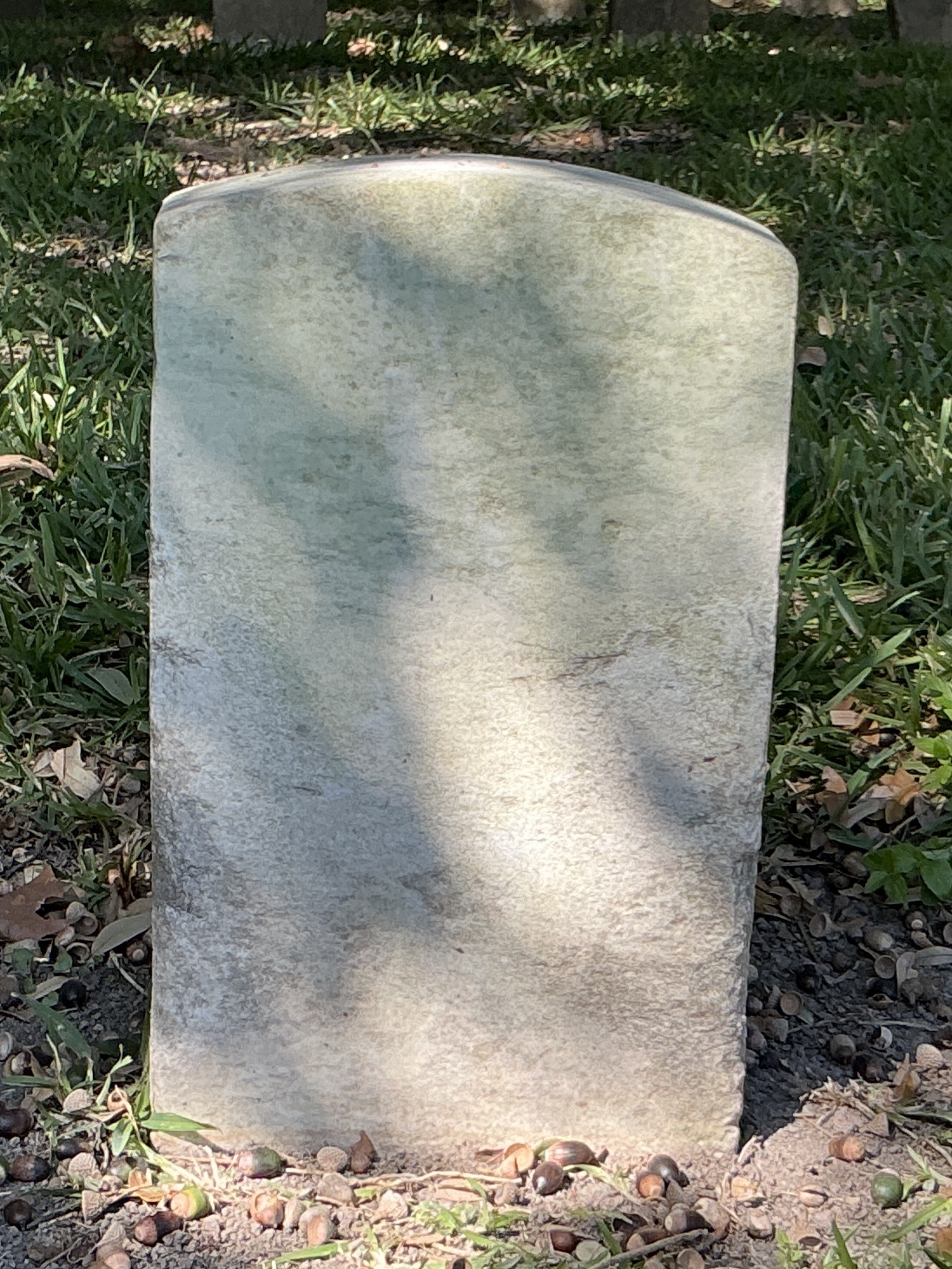 Back of historic upright marble headstone with recessed shield with recessed lettering face.