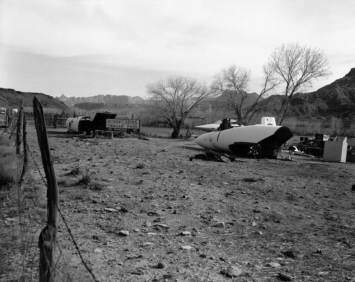 A portion of the roadside junk lining State Route 15 (now state Route 9) at the 101 Ranch service station. Rocket sleds from United States Air Force (USAF) Hurricane Supersonic Research Site on Hurricane Mesa, surplus materials from the Coleman Engineering Company .