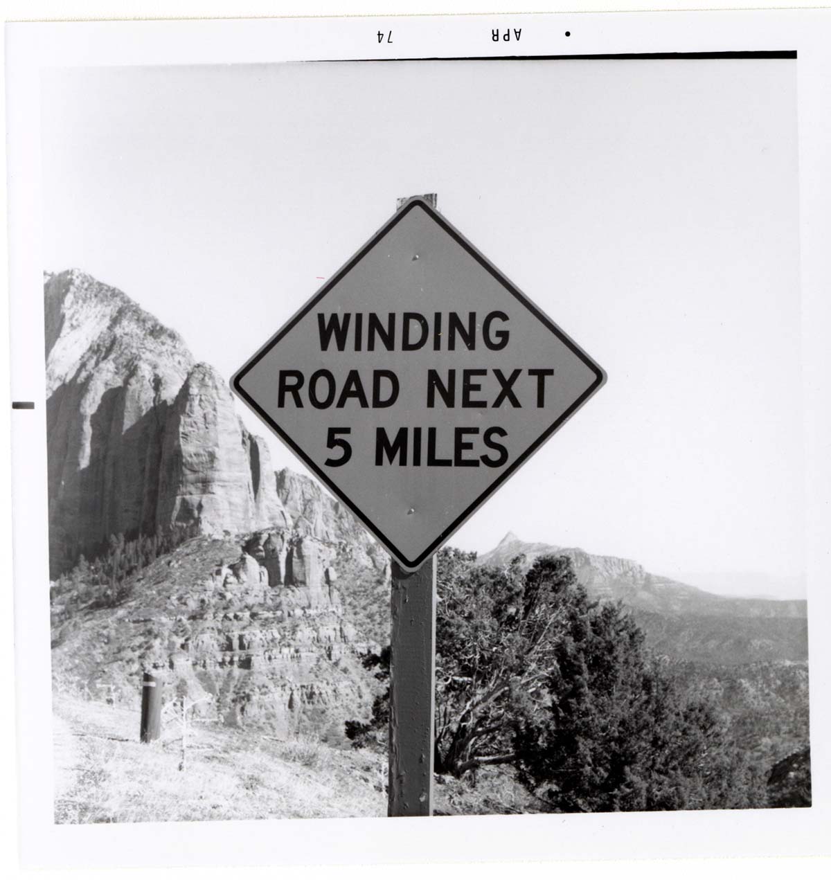 Road sign reading 'Winding Road Next 5 Miles' in Kolob Canyon.