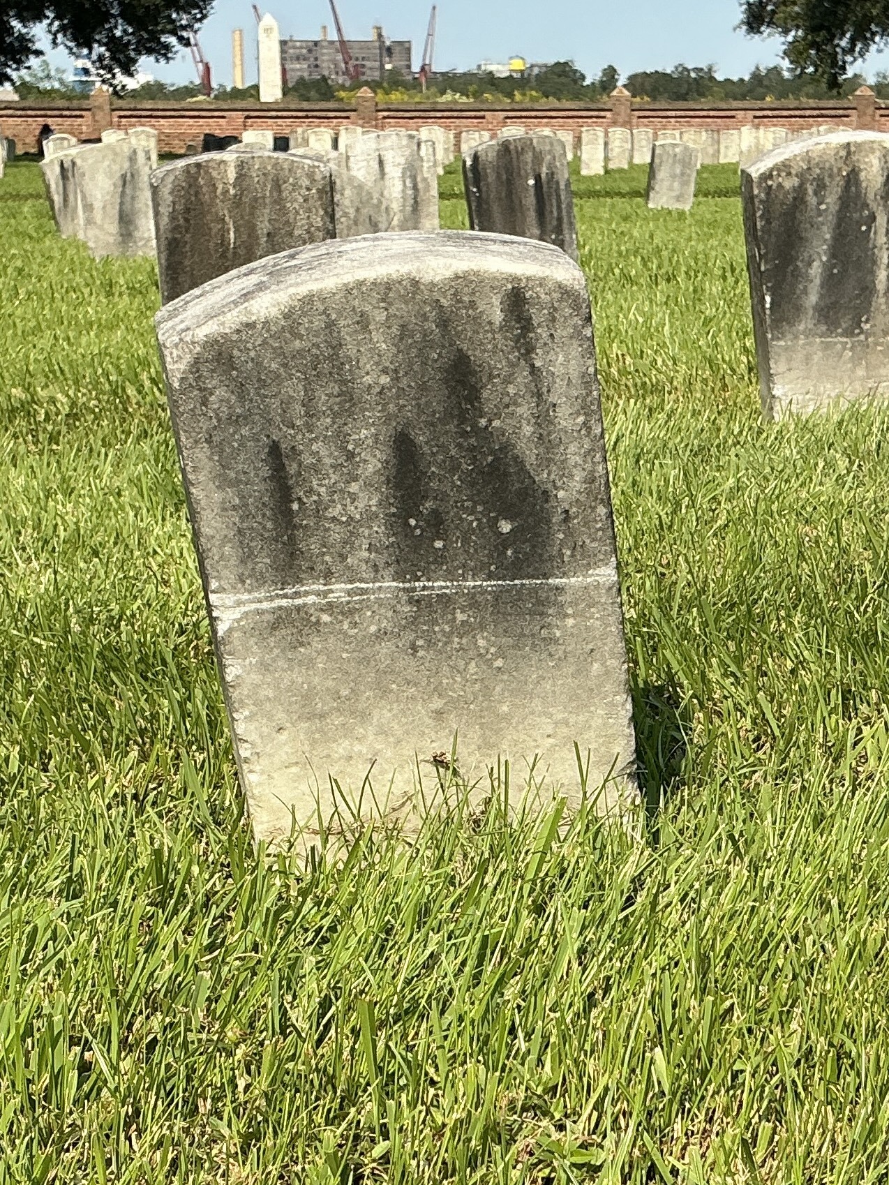 Back of historic upright marble headstone with recessed shield face.