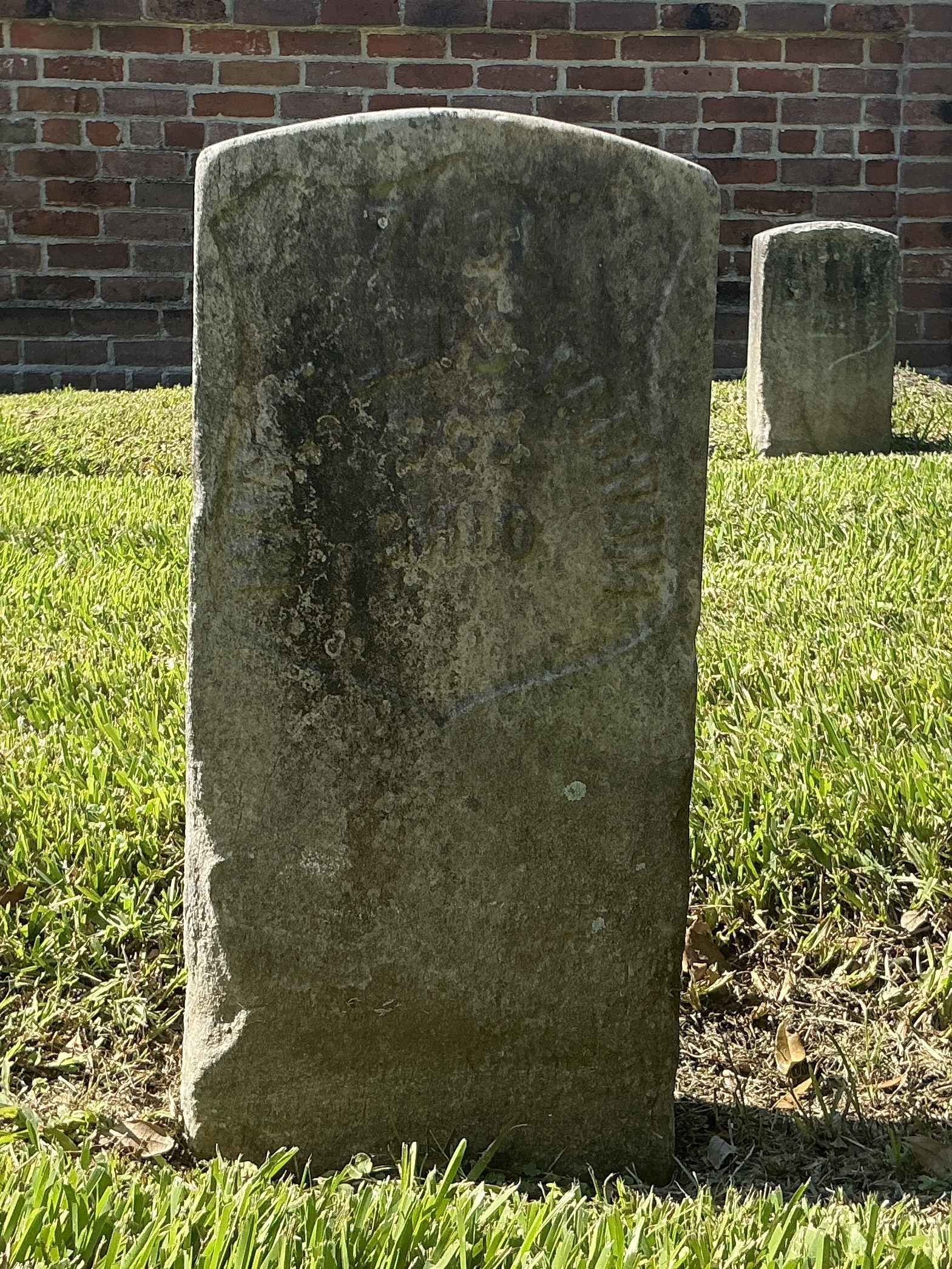 Front of historic upright marble headstone with recessed shield face.
