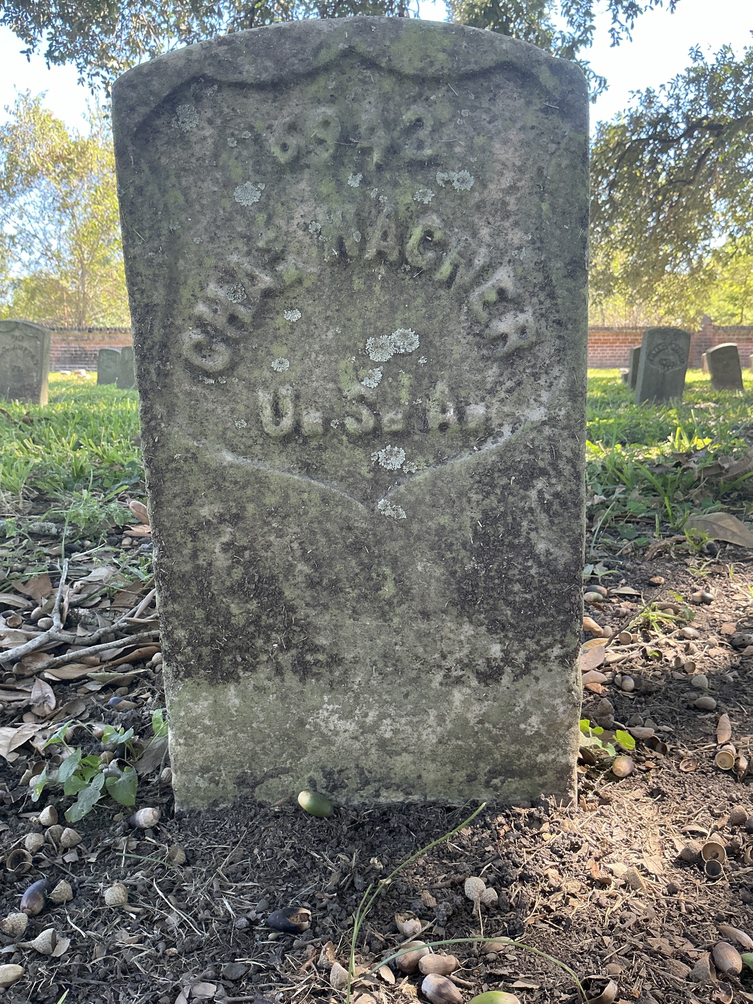 Front of historic upright marble headstone with recessed shield face.