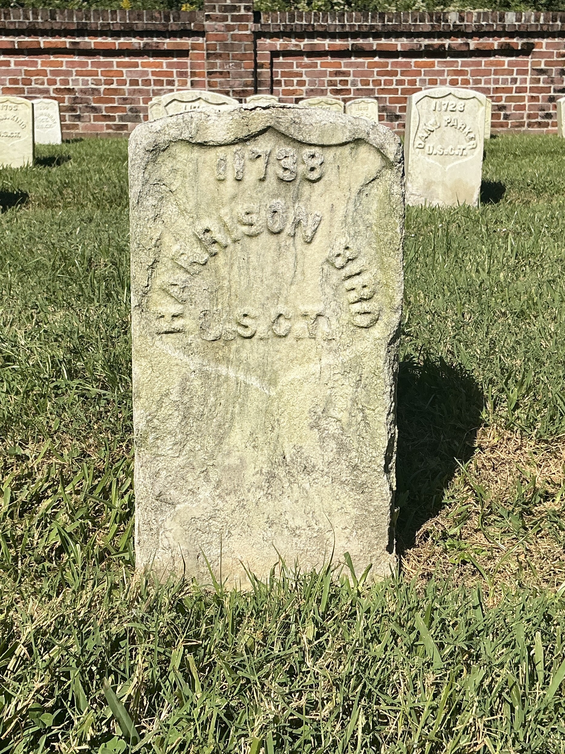 Front of historic upright marble headstone with recessed shield face.