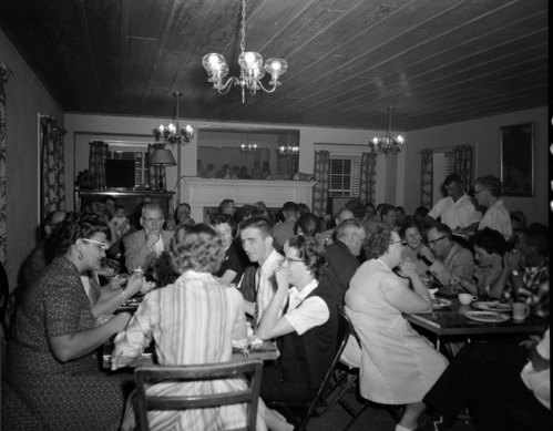 Men and women eating dinner at Harry Brockmeier's retirement party in the ranger dormitory.