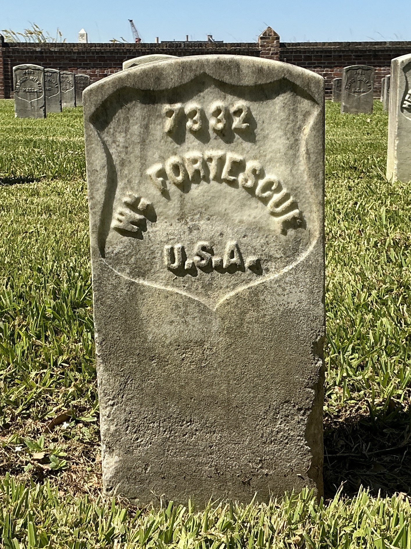 Front of historic upright marble headstone with recessed shield face.