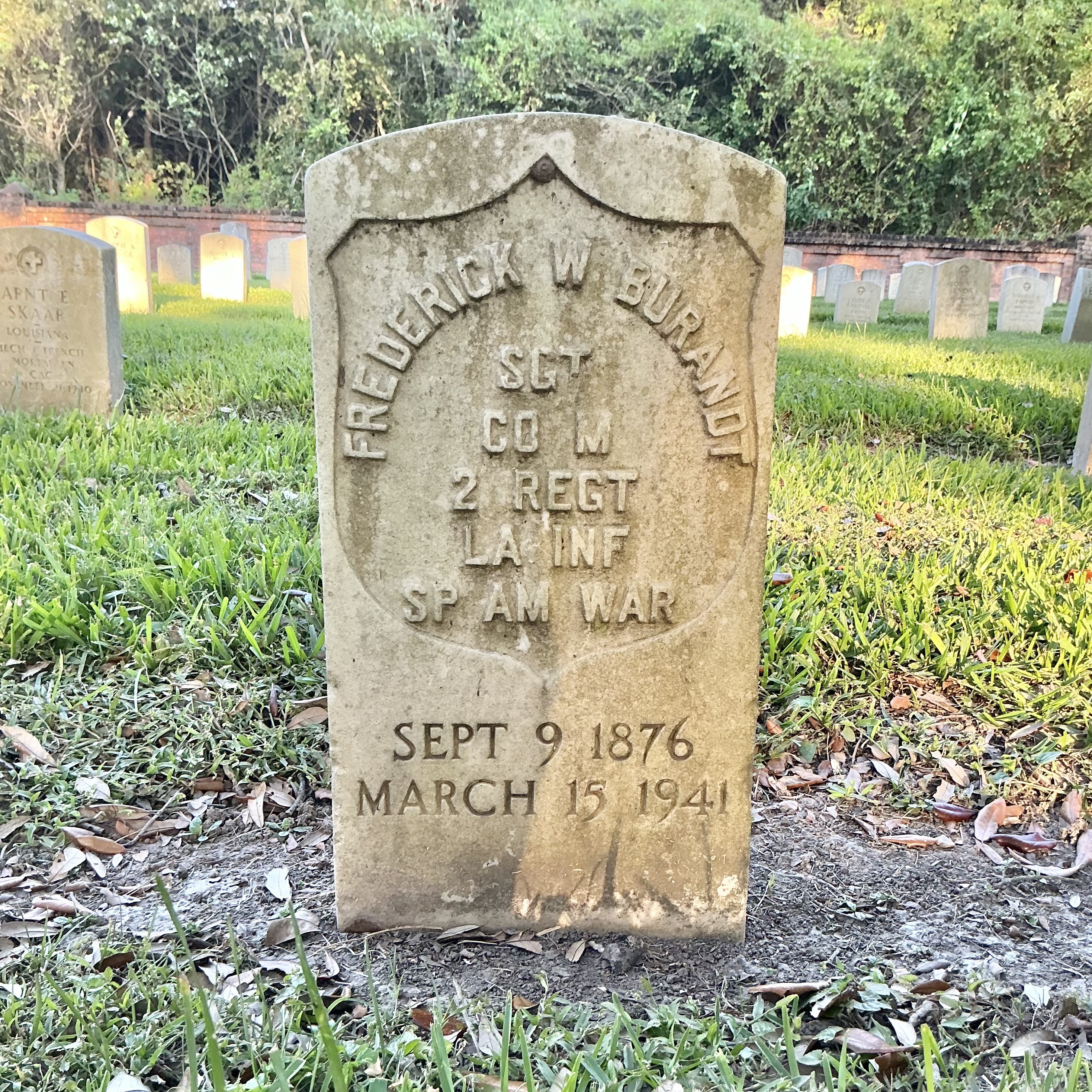 Front of historic upright marble headstone with recessed shield face.