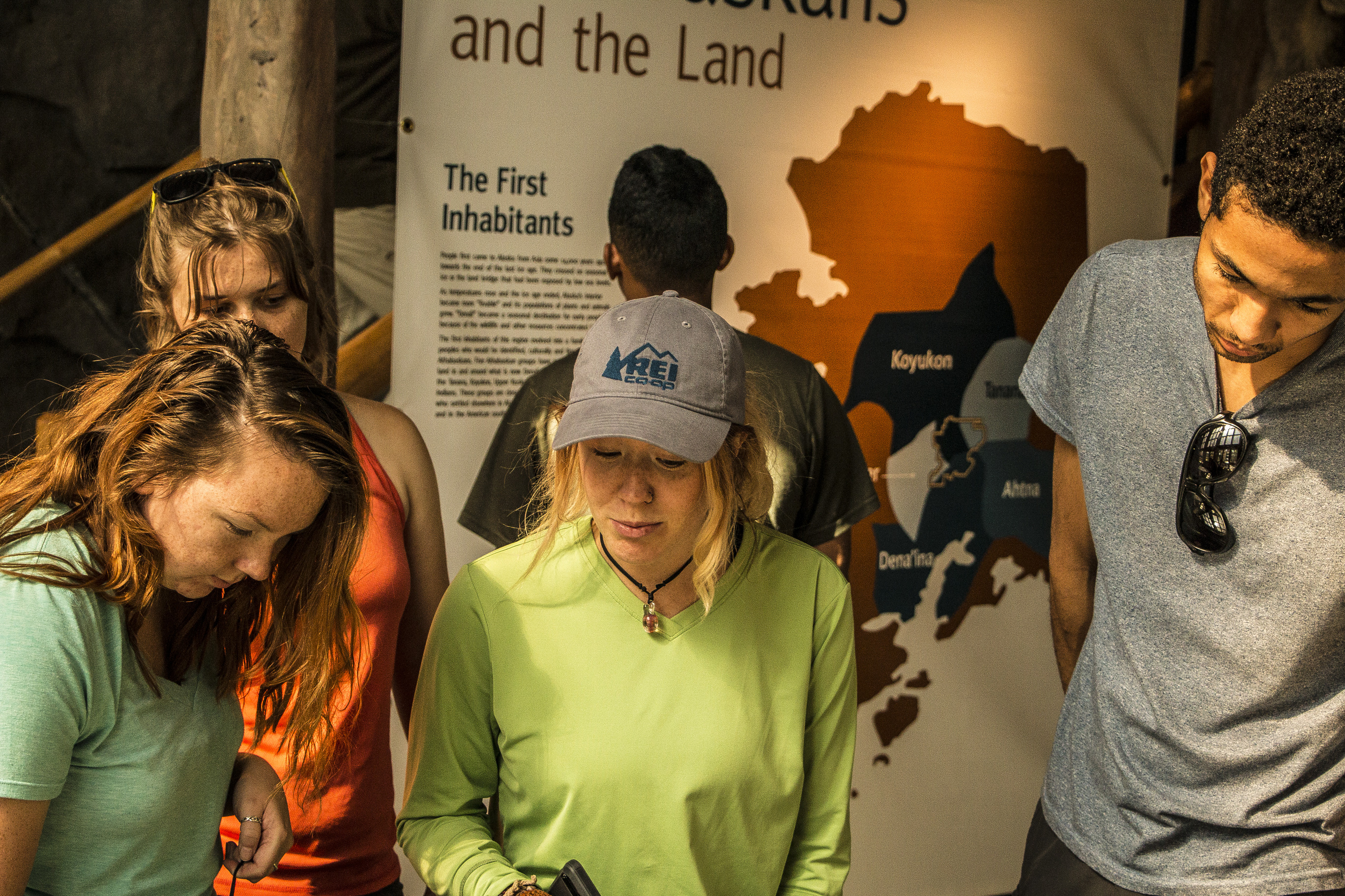 four young adults looking at exhibits in a visitor center