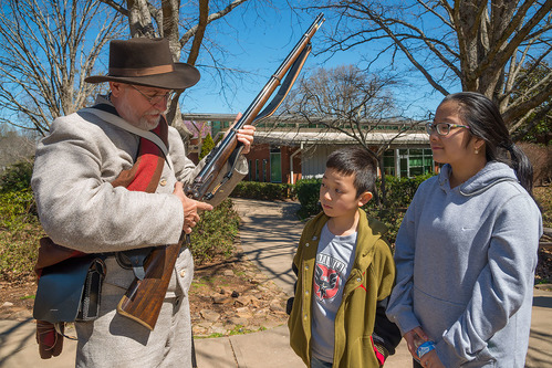 Living historian showing off his weapon to interested visitors