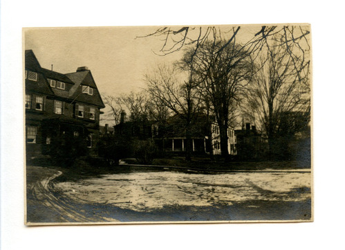 Black and white photograph of American Shingle style home with Georgian mansion in the distance.