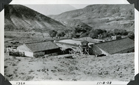 This is an historic black and white photograph from the Scotty's Castle Historic Photograph Collection, Death Valley National Park of Scotty's Castle Stables looking southwest down Grapevine Canyon. October 8, 1928. Photographed by Mat Roy Thompson.