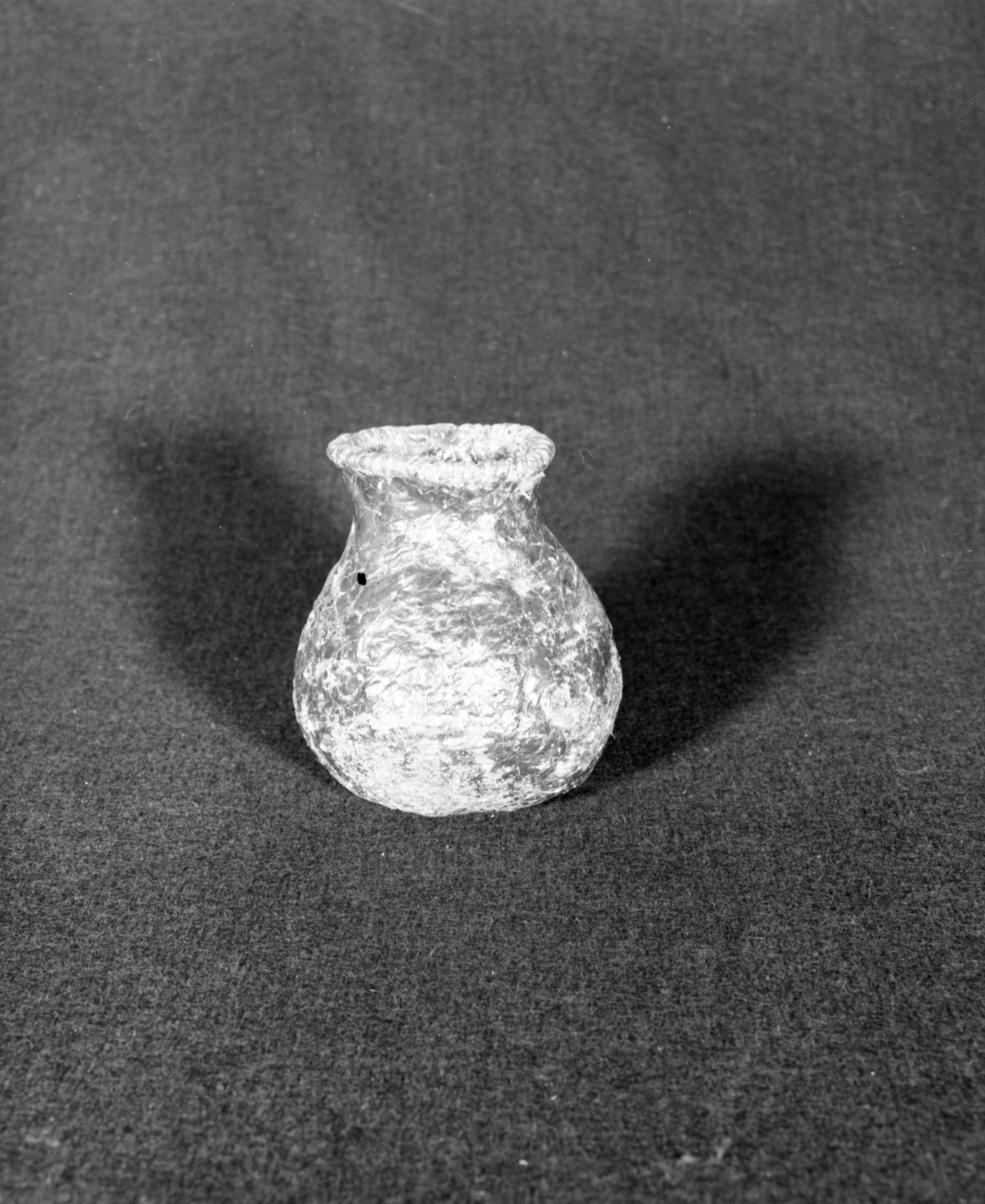 Marie Rozier Collection, Catalog No. 114. Object: Model Havasupai water jug. Dimensions: 5 1/2 x 4". Materials: willow?, pinyon pine pitch, horsehair handle. Technology: diagonally twined, up to right slant of turns, some three strand twining. Collection History: Made by Topsy. Purchased at Havasupai reservation at bottom of Grand Canyon. Photographed by Michael Dixon, December 1982. Marie Rozier Collection.