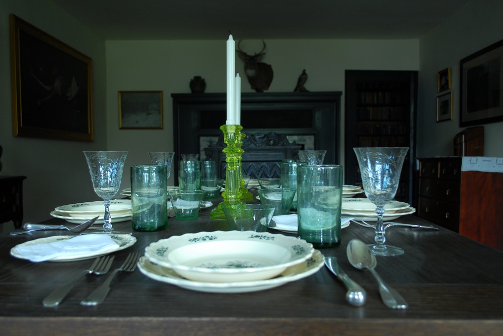A dining room table covered in a six piece dish set.