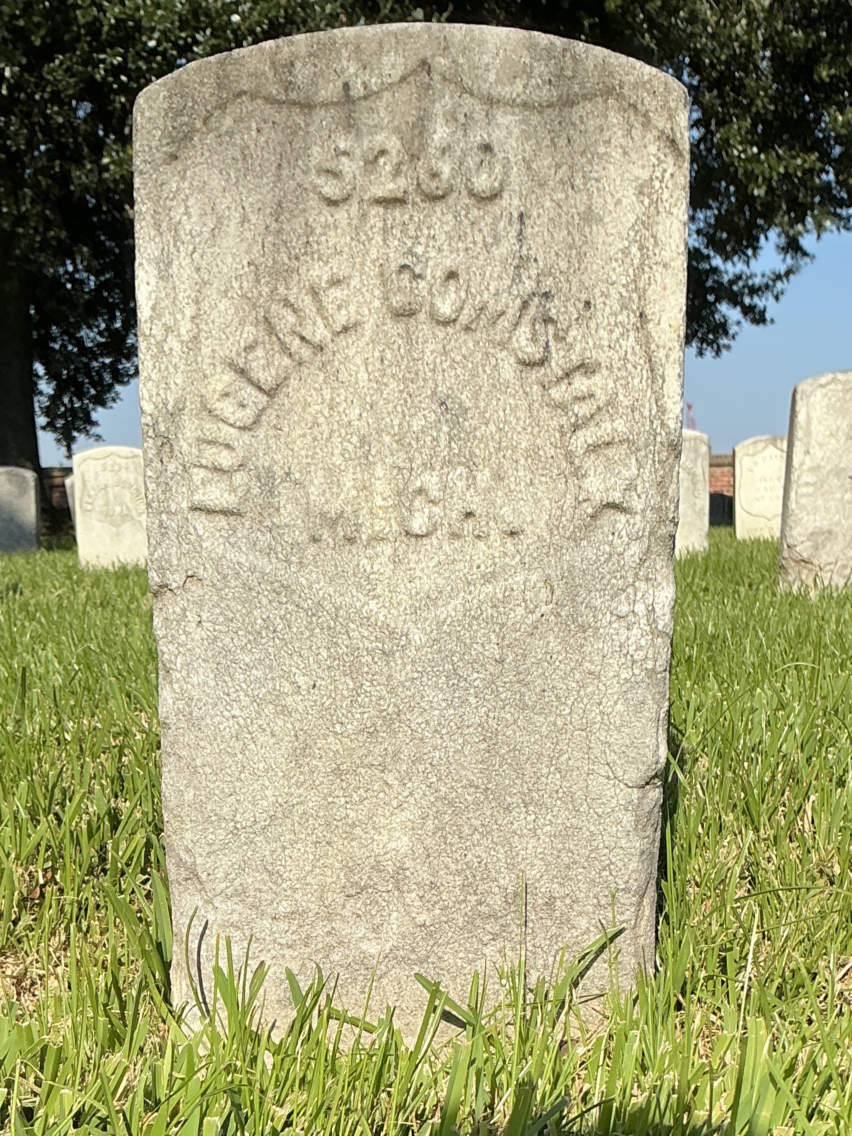 Front of historic upright marble headstone with recessed shield face.