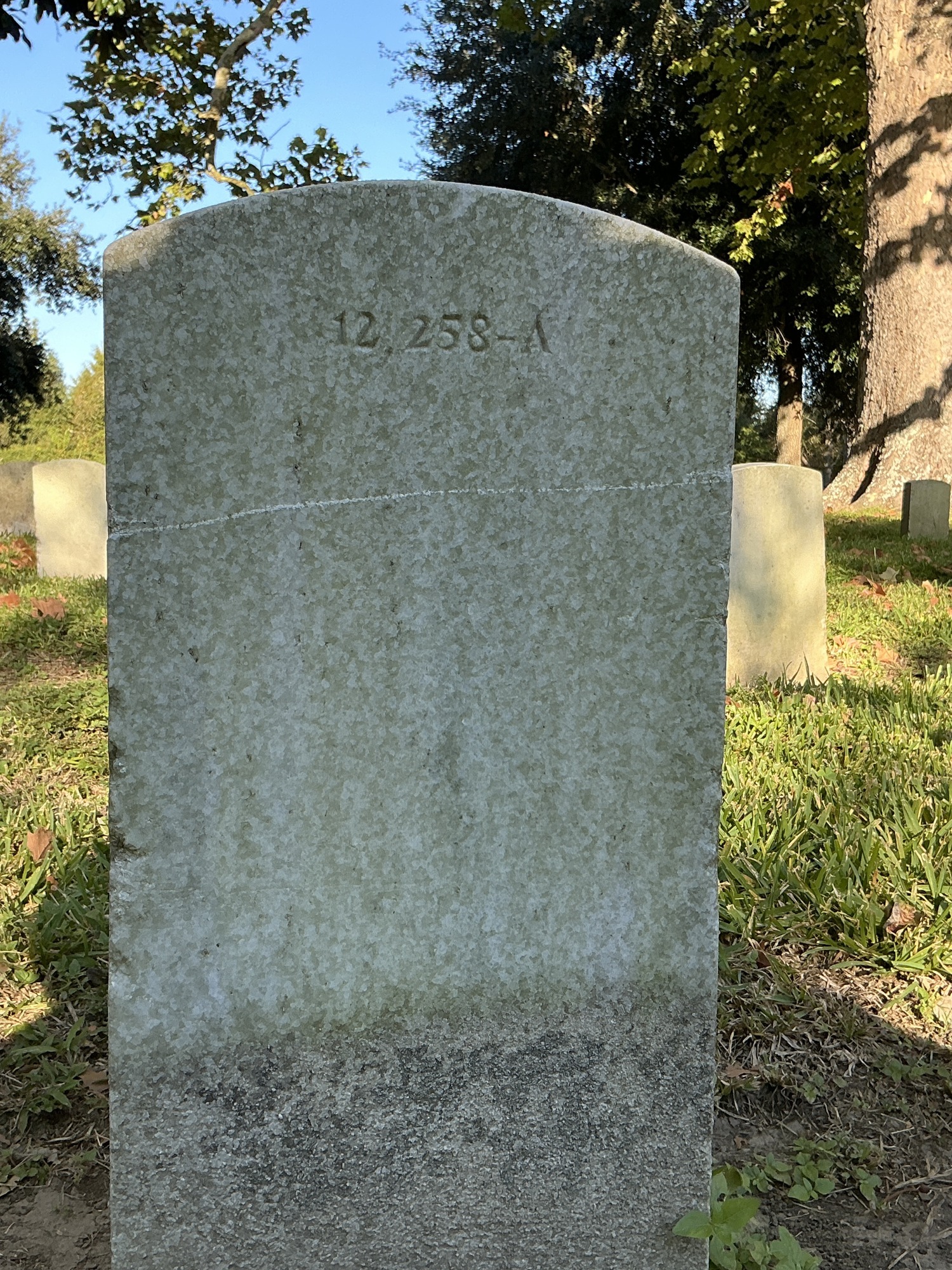 Back of upright marble headstone with flat face.