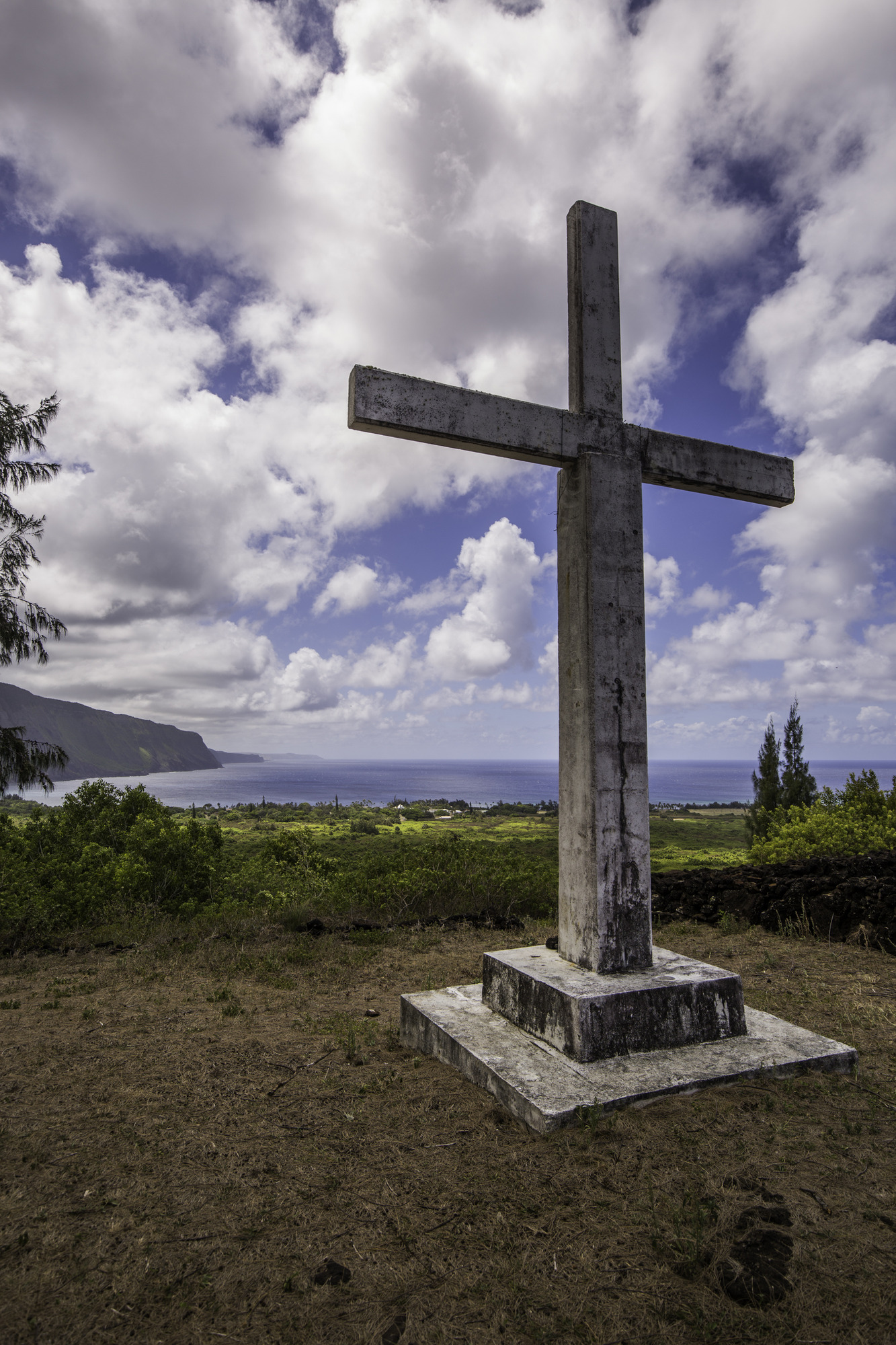 A large white, grey cross and a vista of the ocean. 