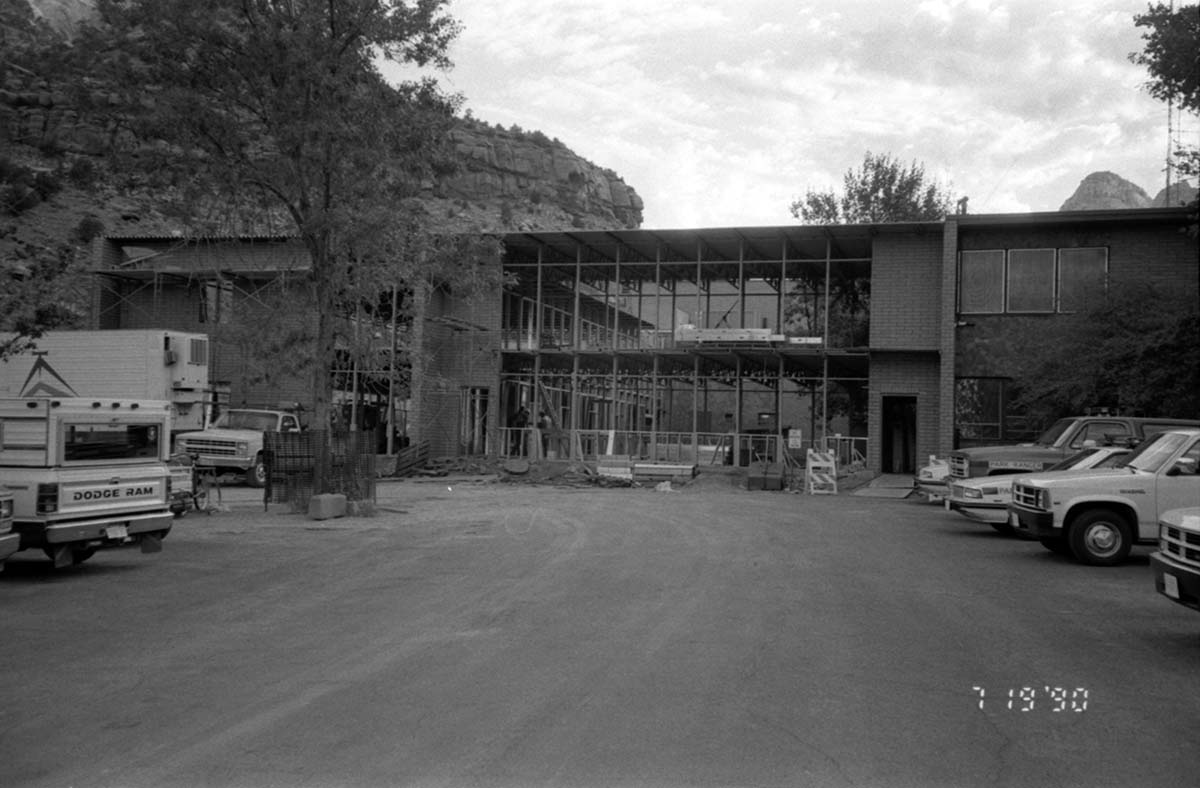 Vehicles parked in the parking lot and the new addition of headquarters during construction.