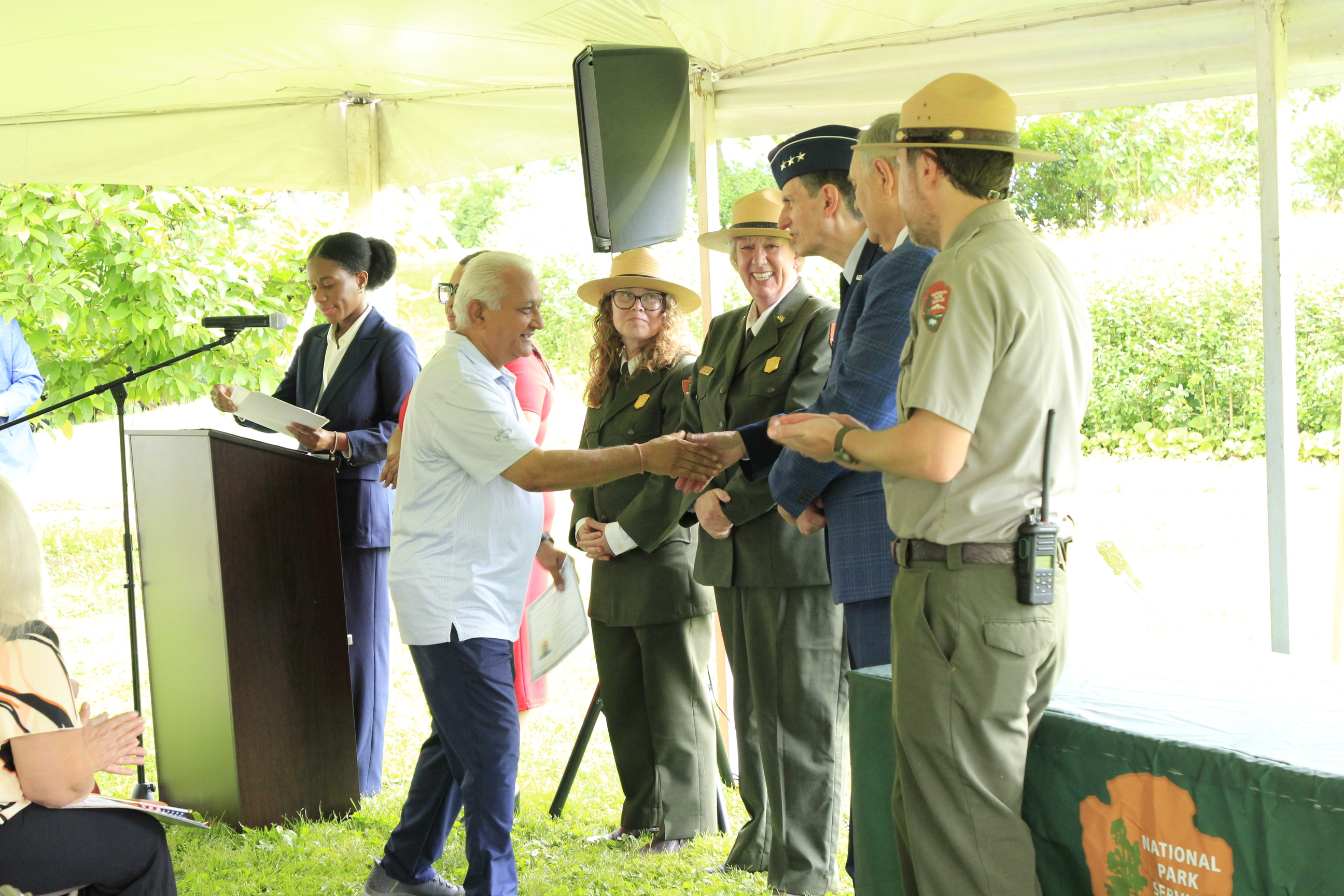 A row of people standing and shaking hands. 