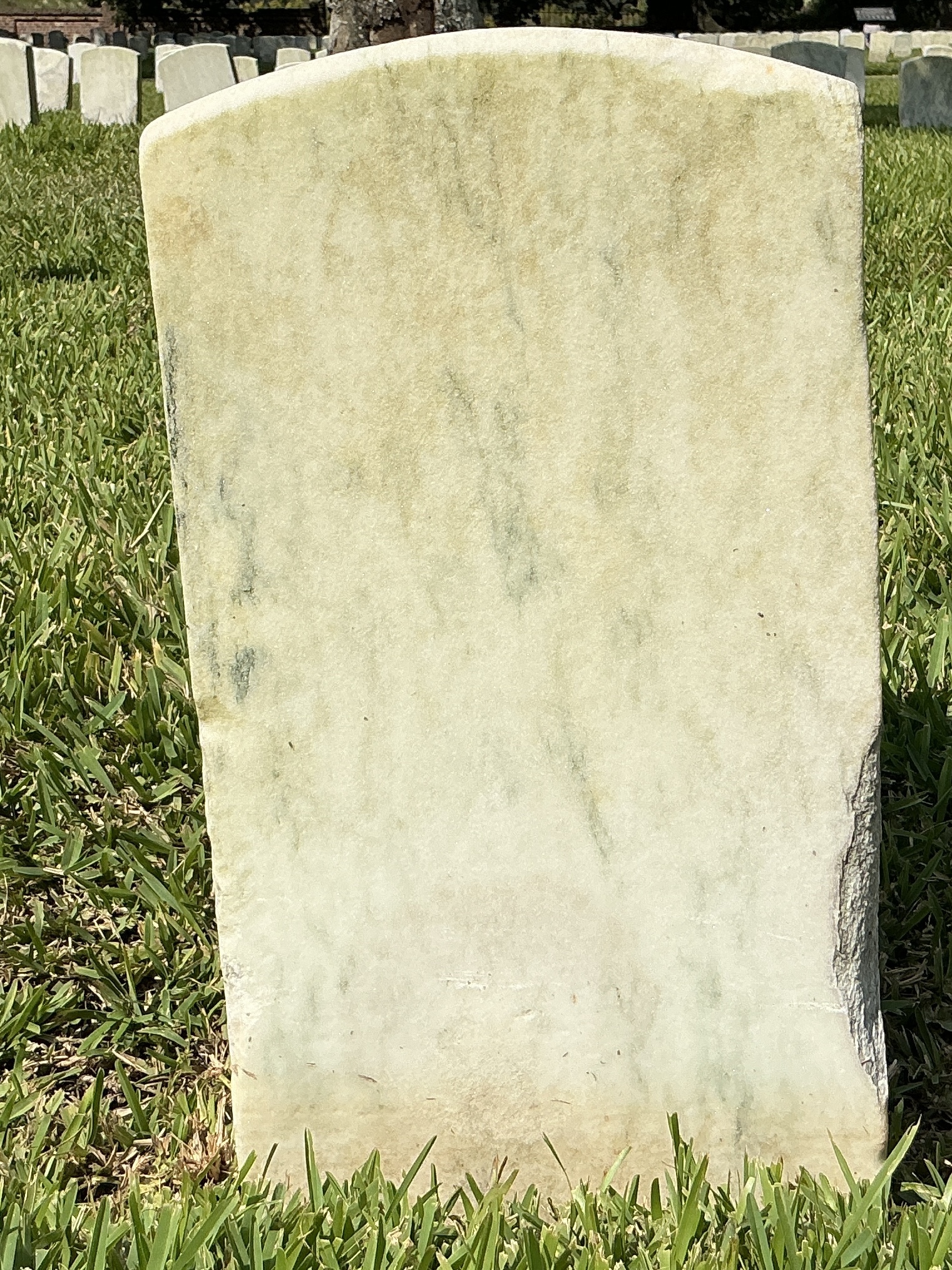 Back of historic upright marble headstone with recessed shield with recessed lettering face.