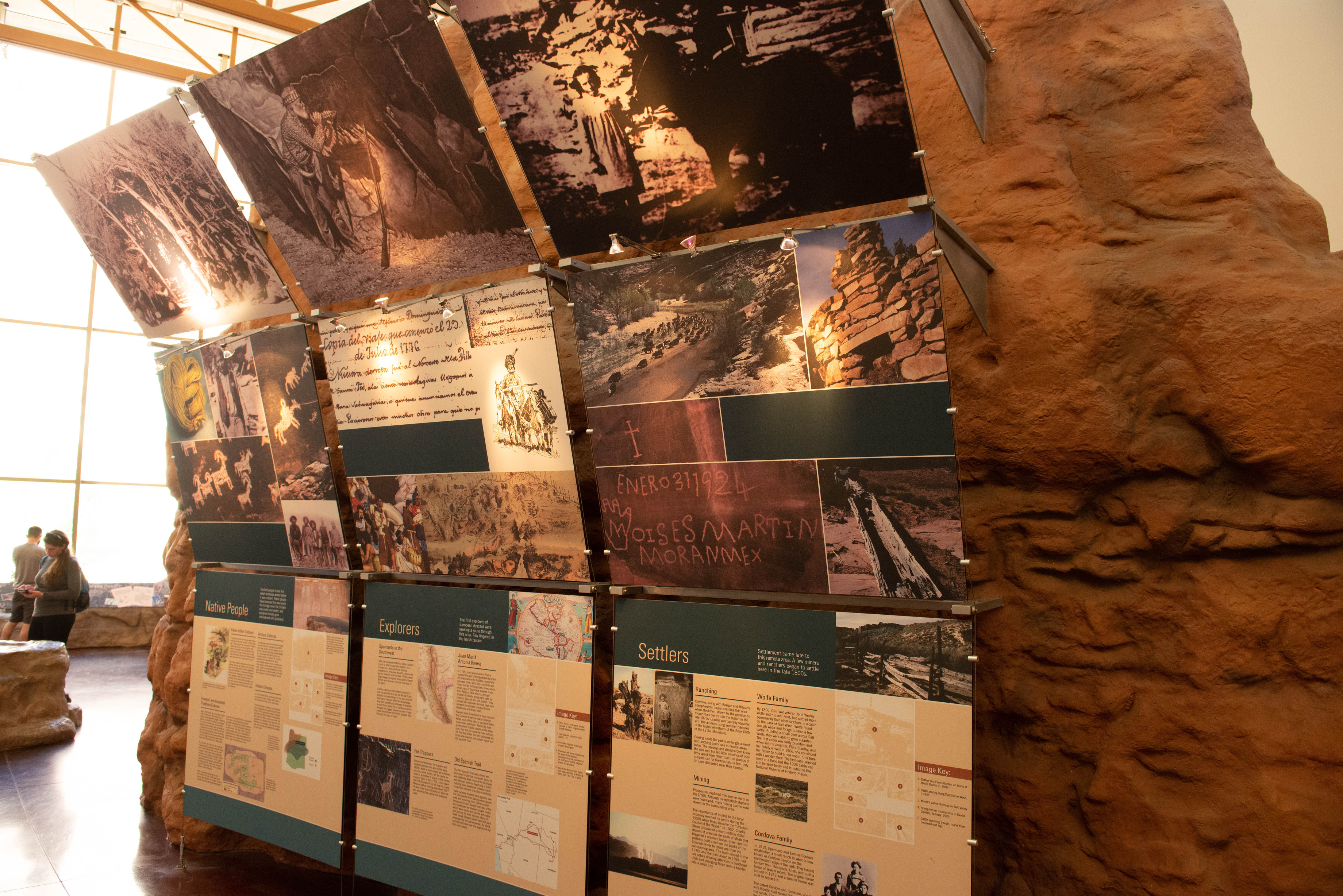 an exhibit display of text and images with nine panels arranged in a square