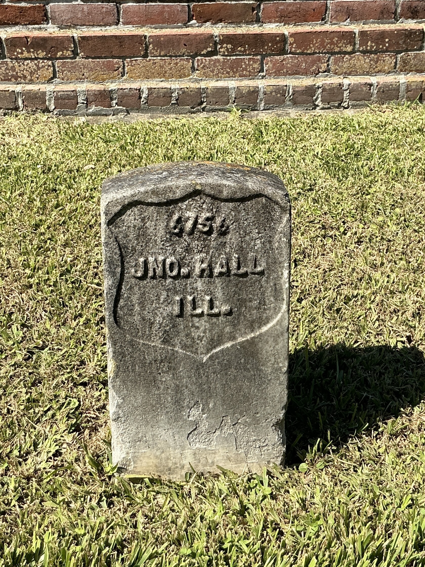 Front of historic upright marble headstone with recessed shield face.