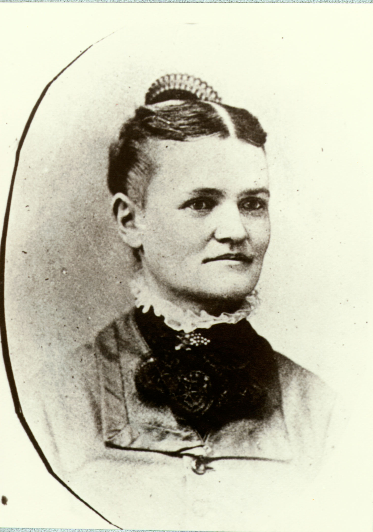 A 1879 portrait photo depicts a woman in a dress with parted hair and a comb.