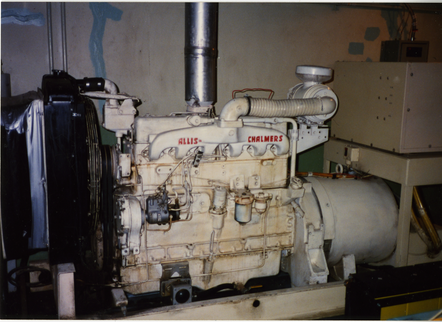 A large white Allis Chalmers generator dominates an underground room