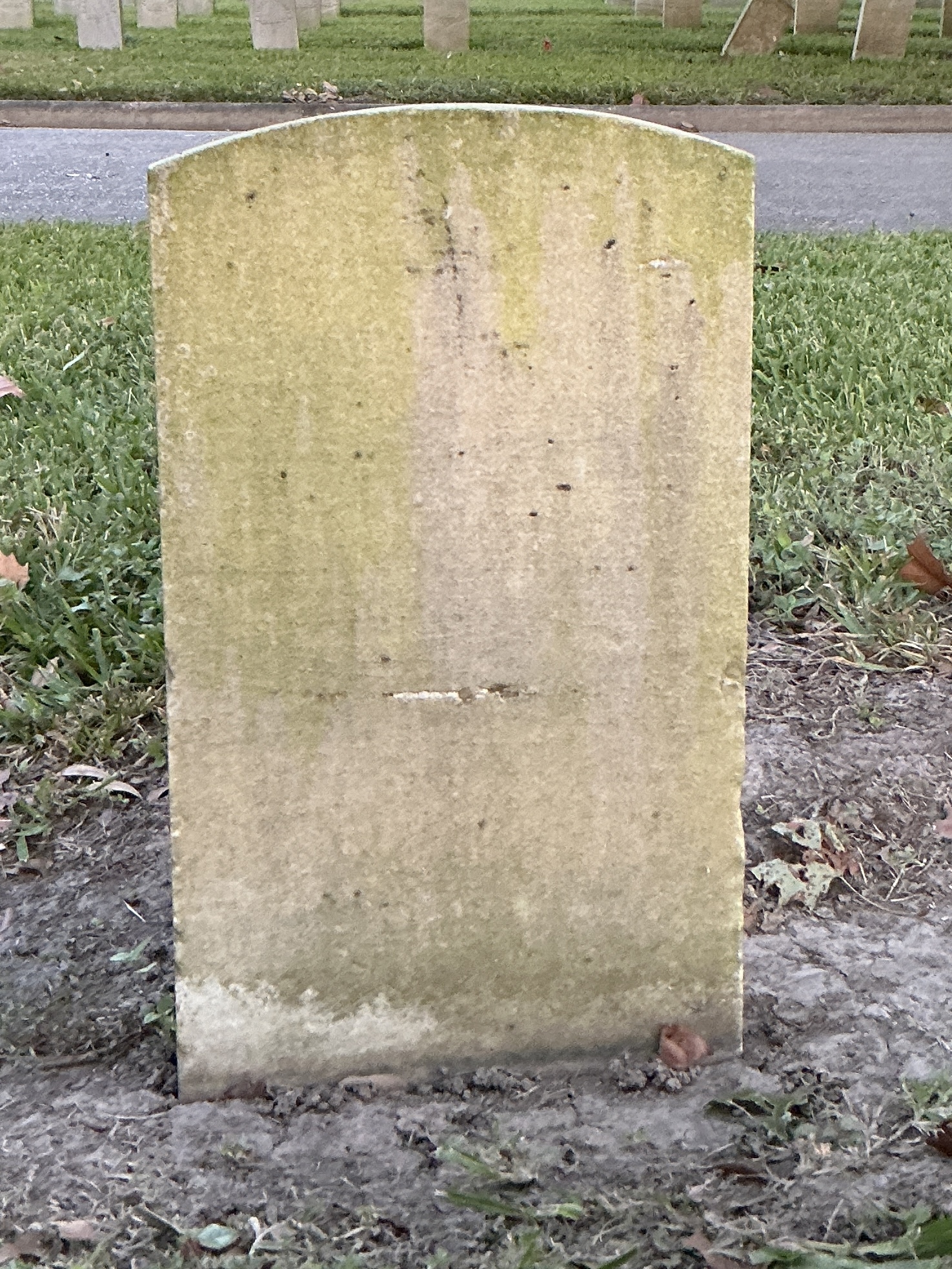 Back of historic upright marble headstone with recessed shield face.