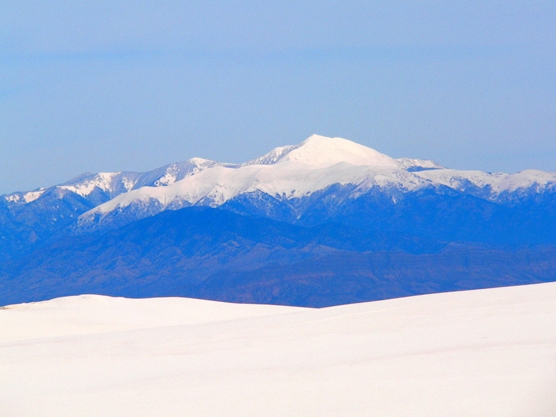 The snow-capped mountain, Sierra Blanca, provides a beautiful backdrop for the bright white sand dunes.