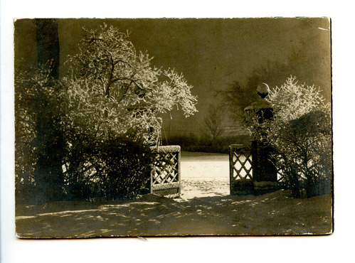 Black and white photograph of gate covered in snow.
