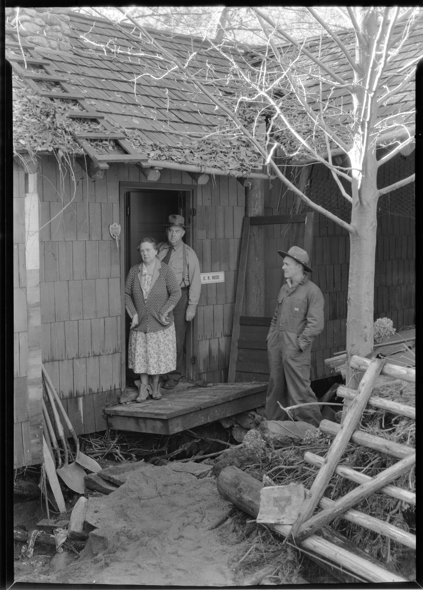 Ranger and Mrs. Reed and Ranger Melvet viewing flood damage at Arch Rock residence.