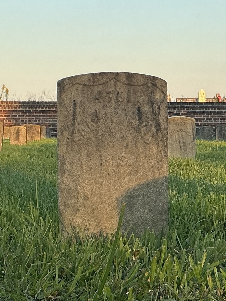 Front of historic upright marble headstone with recessed shield face.