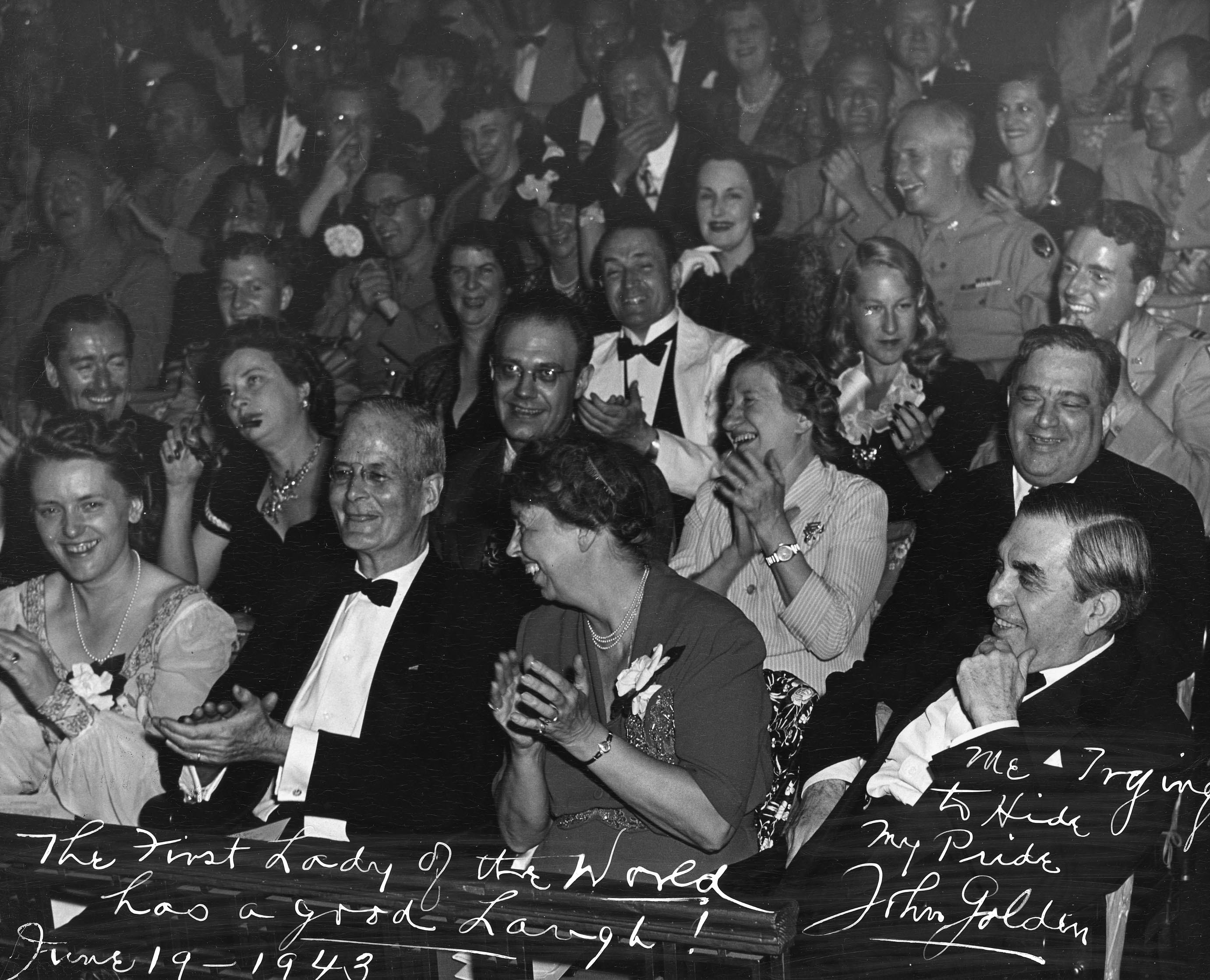 A photo of a crowd attending an event. There is writing at the bottom of the photo.