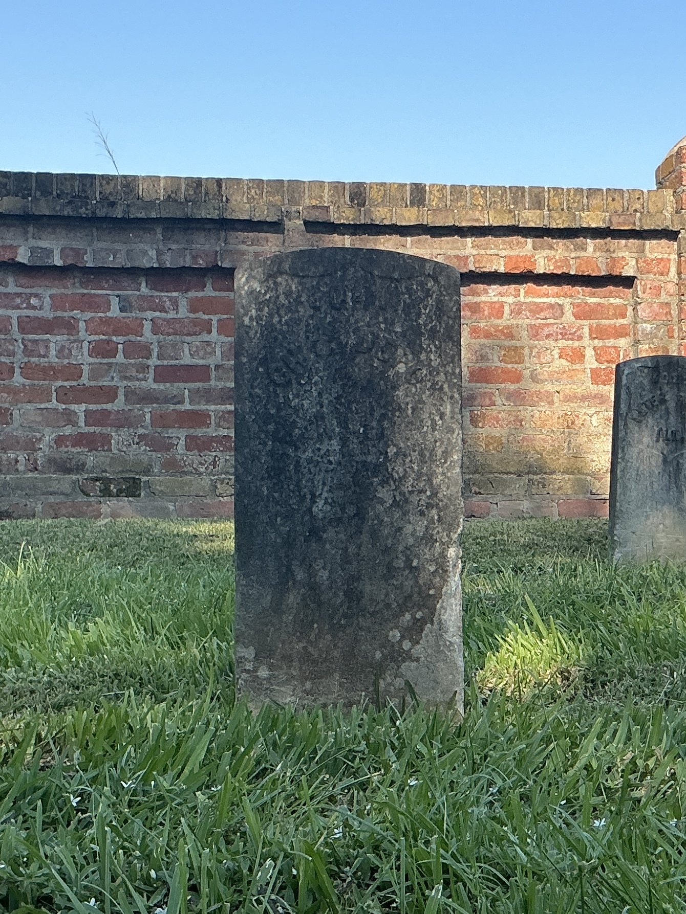 Front of historic upright marble headstone with recessed shield face.