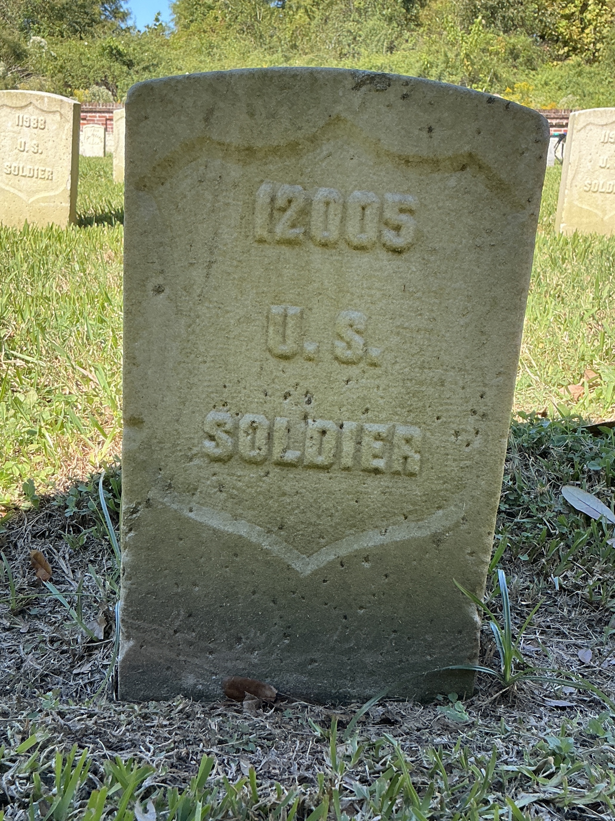 Front of historic upright marble headstone with recessed shield face.