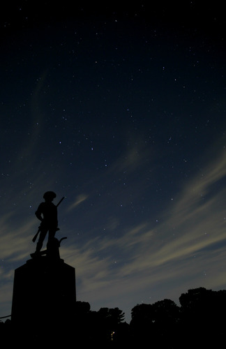 The Minute Man statue by Daniel Chester French against the Summer nights sky