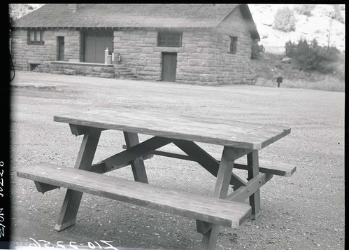 Old type (wooden) campground picnic tables in utility area.