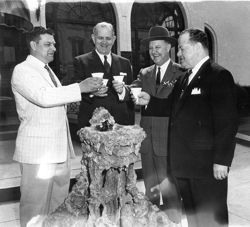Black & white photograph, group portrait
Maurice Bathhouse crystal fountain, 4 men toasting each other with cups of hot water