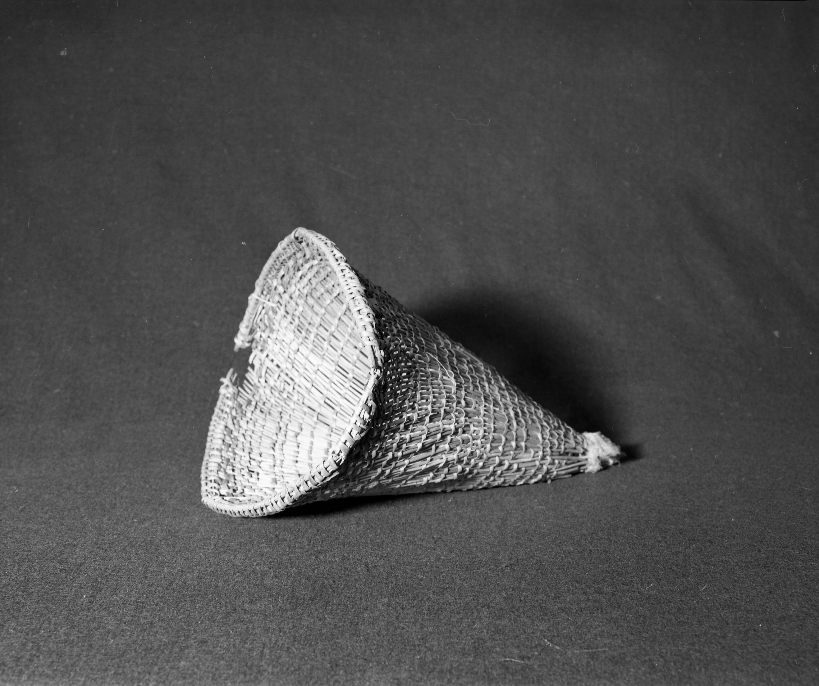 Marie Rozier Collection, Catalog No. 68. Object: Central Miwok burden basket. Dimensions: 10 x 14". Materials: chaparral sticks, split maple, bracken fern root. Technology: diagonally twined, up to right slant of turns, "gauze" sewn to pointed end. Collection History: Purchased by Annie Teague in Tuolumne ca. 1910. Photographed by Michael Dixon in December 1982. Catalogued by Craig Bates and Barbara Beroza. Yosemite Collections, National Park Service.