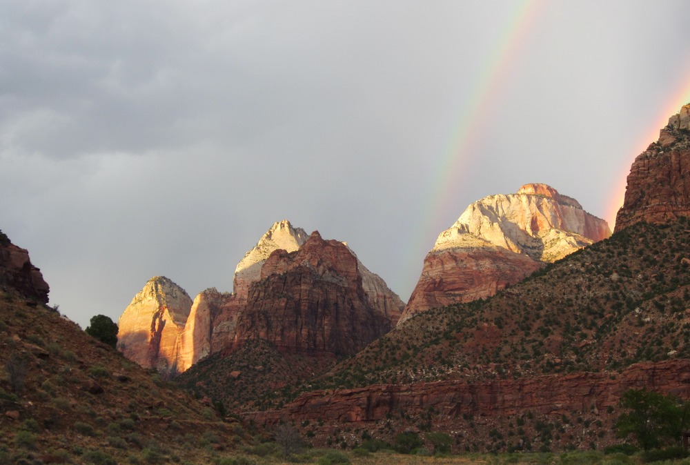 A twin rainbow surrounds the East Temple, a large sandstone peak.