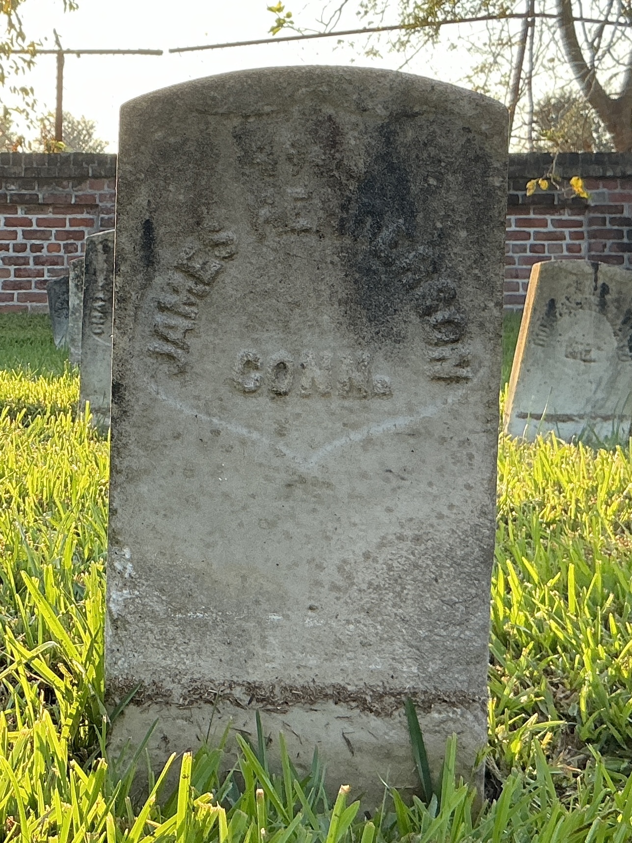 Front of historic upright marble headstone with recessed shield face.