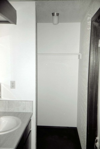 Sink and storage area in bathroom of barracks. [Image possibly for comparative housing study]