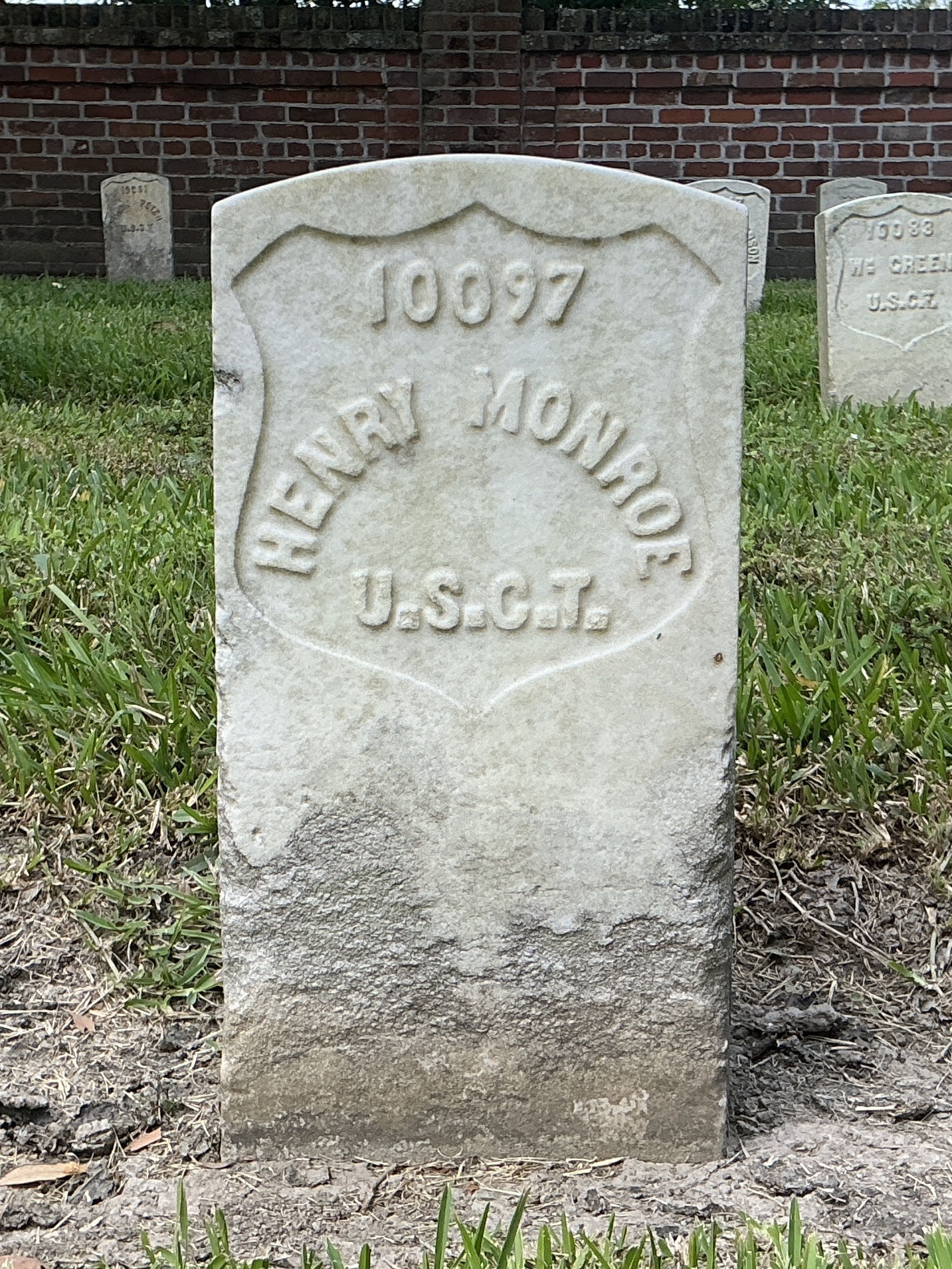 Front of historic upright marble headstone with recessed shield face.