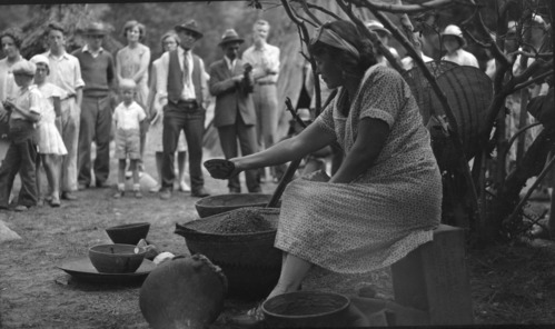 Grace Anchor making manzanita cider as visitors watch. All baskets are from Yosemite Museum.
