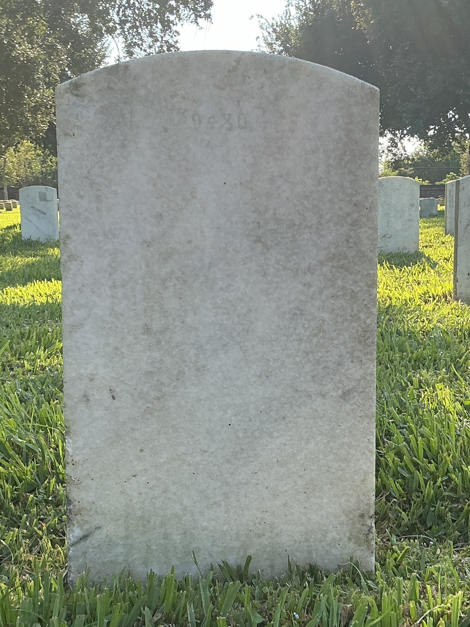 Back of upright marble headstone with flat face.
