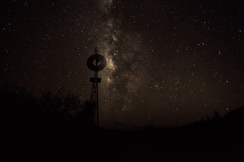 The glow of the Milky Way backlights the silhouette of an old windmill.