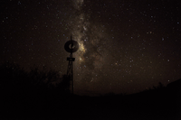 The glow of the Milky Way backlights the silhouette of an old windmill.