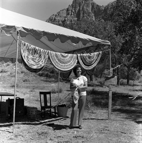 Nancy Wilson standing with her demonstration of braided rag rugs at the second annual Folklife Festival, Zion National Park Nature Center, September 7-8, 1978.