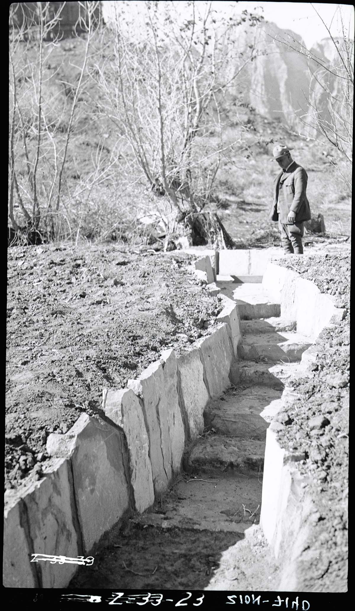 Irrigation ditches with ranger looking at water drops.